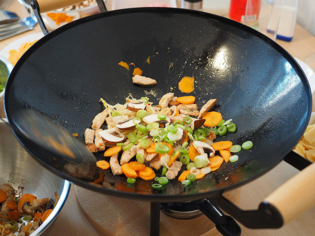 Carbon Steel wok with uncooked veggies in a home kitchen