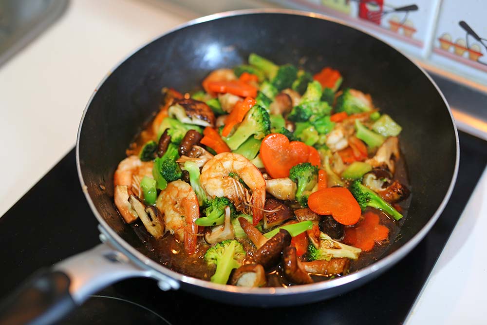 stir fry noodles with shrimp and vegetables in a stir fry pan