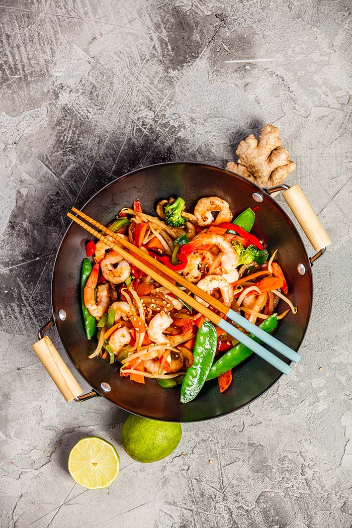 stir fry noodles with shrimp and vegetables in a carbon steel wok