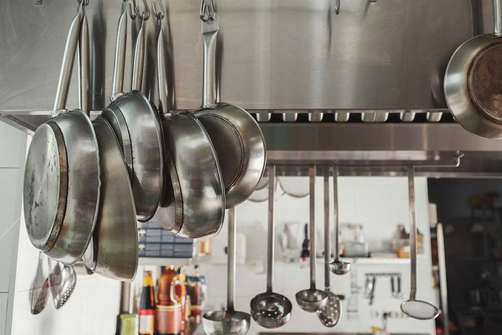 Stainless steel pans hanging in a restaurant kitchen