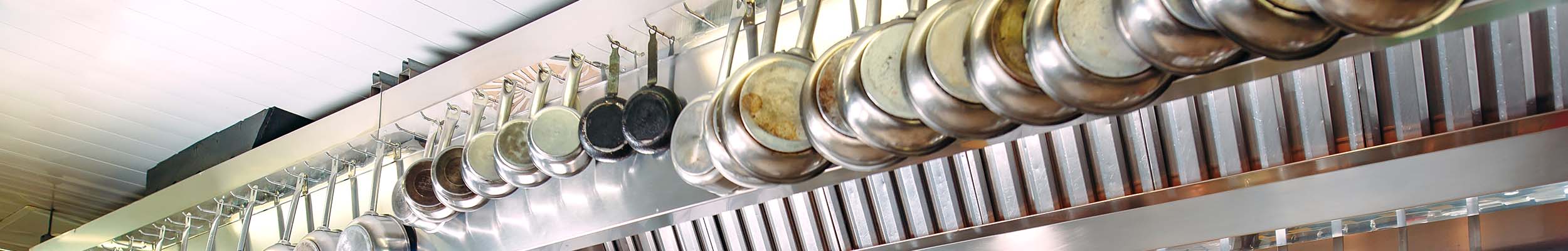 Dozens of pans hanging in a commercial kitchen