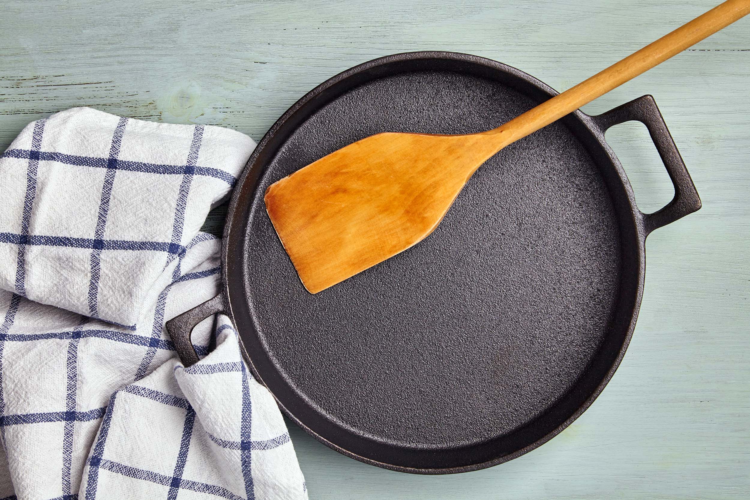 Wooden spatula on a new cast iron pan